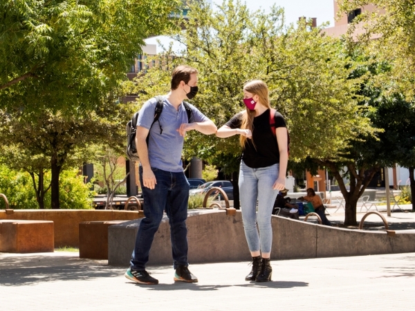 Two students bumping elbows